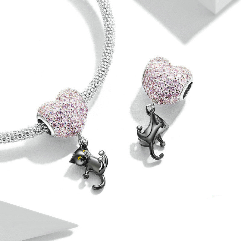 Matching Cat Heart Charms displayed on a bracelet, featuring a pink heart and black cat design. A stylish addition to any charm collection.