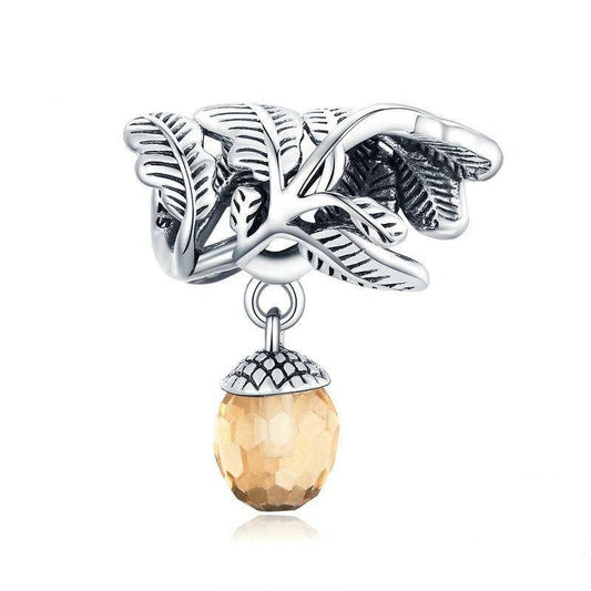 Elegant acorn charm with intricate leaf design and amber gemstone.