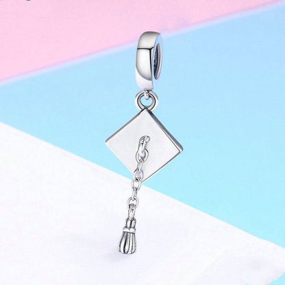 Graduation hat charm on pastel background