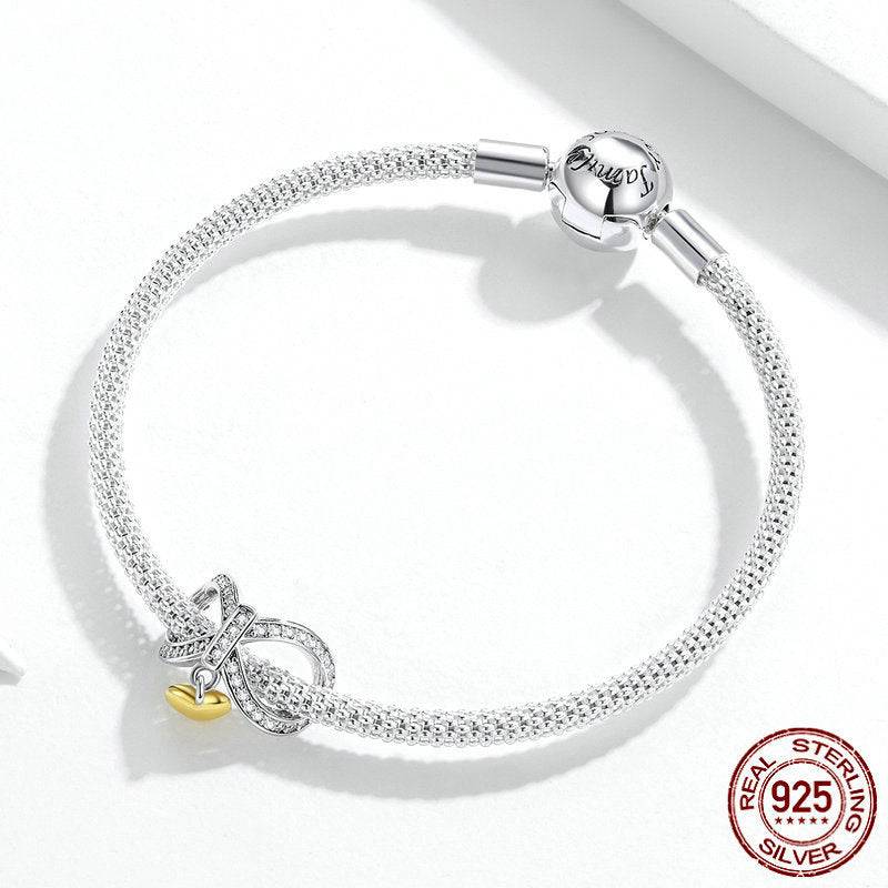 Sterling silver bracelet featuring a heart infinity charm with a crystal-studded infinity symbol and a gold heart pendant.