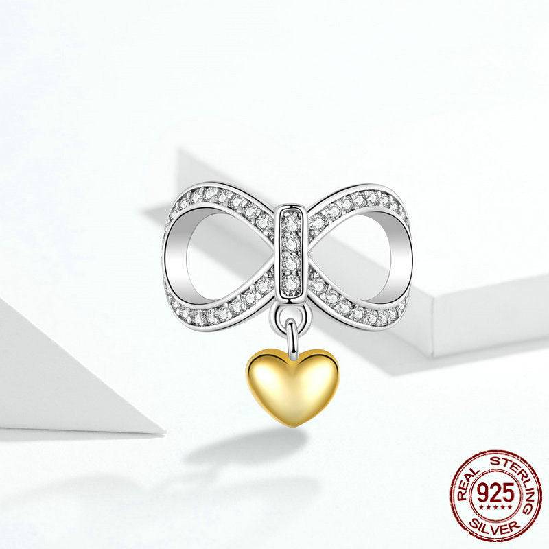 Heart infinity charm made of sterling silver with crystal accents and a gold heart pendant, ideal for bracelets or necklaces.