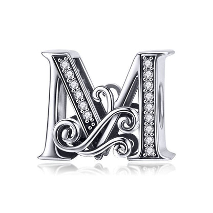 Ornate letter M charm with swirl design