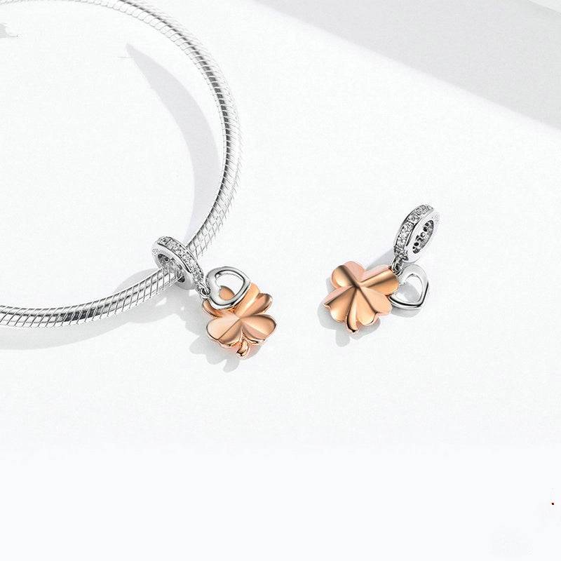 Gold clover charm on bracelet with heart design