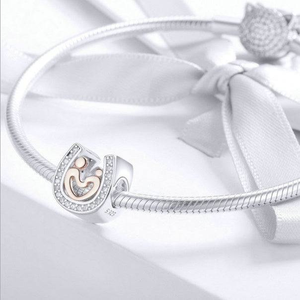 Horseshoe charm on a silver bracelet with elegant design.