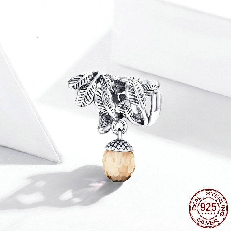 Detailed acorn charm with amber gemstone and sterling silver leaves.