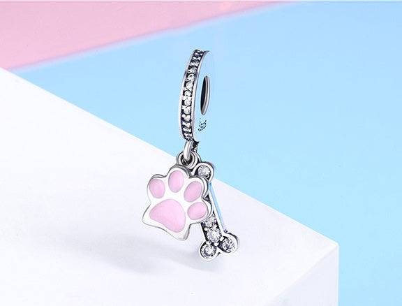 Stylish Pink Bone Charm with pink paw and diamanté bone, made of sterling silver, perfect for pet lovers' jewelry collections.