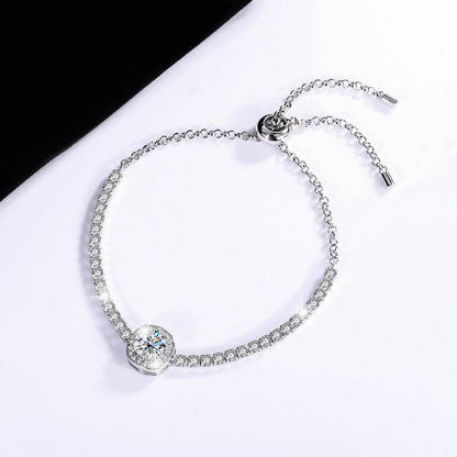 Elegant silver moissanite galaxy bracelet with a clear central stone, displayed on a black and white background.