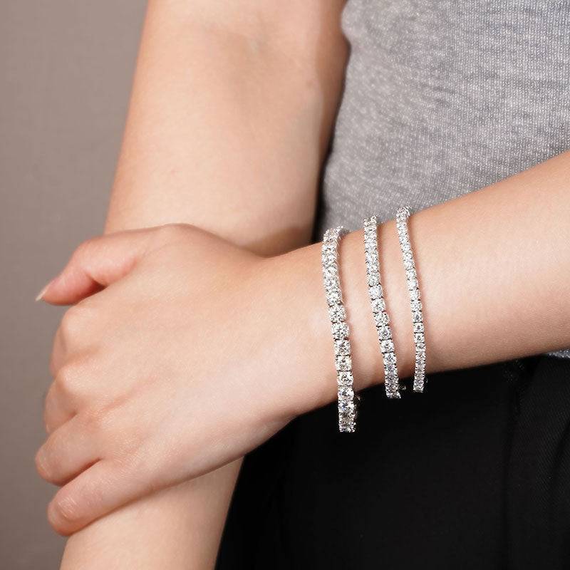 Model wearing multiple Moissanite Tennis Bracelets showcasing their sparkling Moissanite stones and sleek sterling silver design.