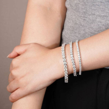 Model wearing multiple Moissanite Tennis Bracelets showcasing their sparkling Moissanite stones and sleek sterling silver design.