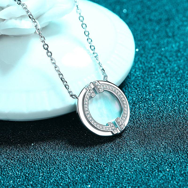 Circular moissanite necklace placed on a decorative surface, showcasing its refined craftsmanship and sparkling accents.