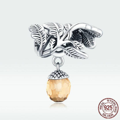 Sterling silver acorn charm with amber gemstone and leaf details.