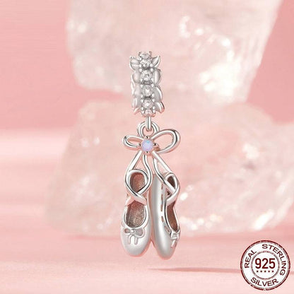 Sterling silver Ballet Shoes Charm with zircon stones displayed on a pink background. Ideal gift for dancers and charm collectors.