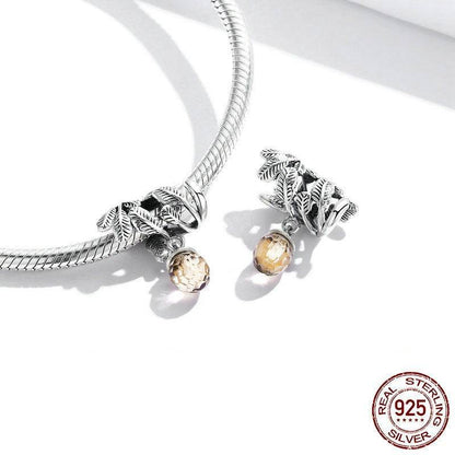 Acorn charm with amber gemstone displayed on a silver bracelet.