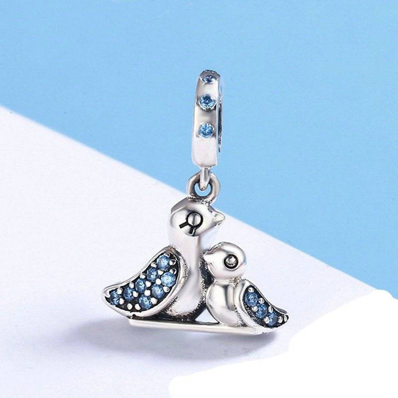 Bird charm with blue accents on a light background